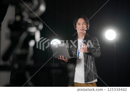 一名男子在舞台上發出指示 一名男子在舞台上發出指示 125338482