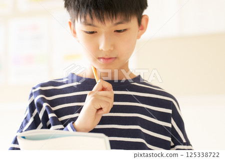 一名男小學生用鉛筆思考 125338722