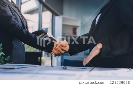 Business success. Business people shaking hands agreement confirmed in the investment business. 125339058