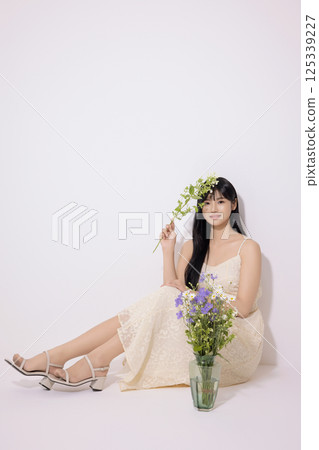 A young woman in her 20s sitting in front of a vase A young woman in her 20s sitting in front of a vase 125339227