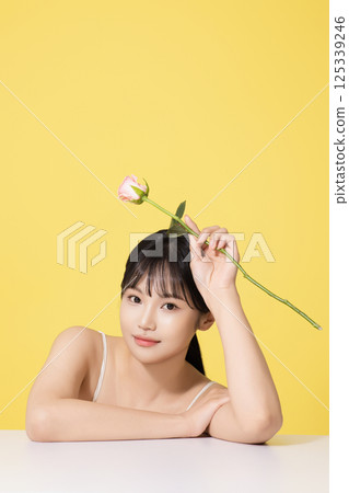 Portrait of a young woman holding a flower 125339246