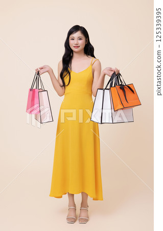 A woman in her 20s holding shopping bags in both hands 125339395