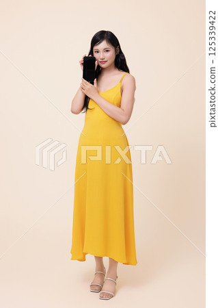 A woman in her 20s holding a smartphone A woman in her 20s holding a smartphone 125339422