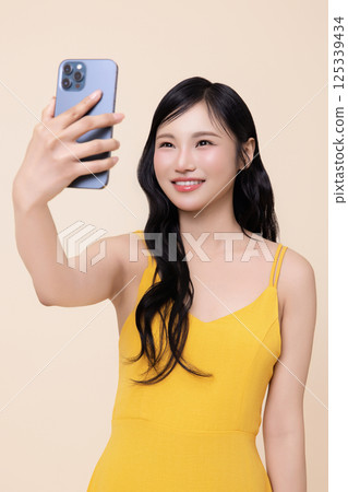 A woman in her 20s holding a smartphone 125339434