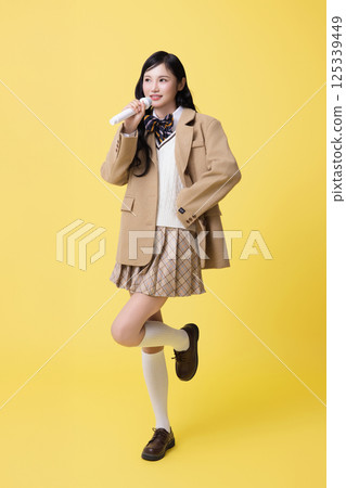 A girl wearing a school uniform and singing with a microphone 125339449
