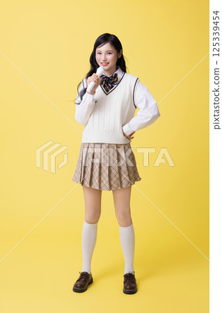 A girl wearing a school uniform and singing with a microphone A girl wearing a school uniform and singing with a microphone 125339454