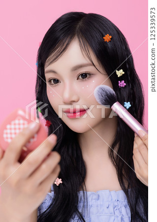 Portrait of young woman posing with cosmetics and wearing pins in her hair 125339573