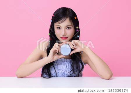 Portrait of young woman posing with cosmetics and wearing pins in her hair 125339574