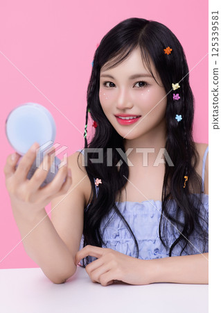 Portrait of young woman posing with cosmetics and wearing pins in her hair 125339581
