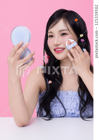 Portrait of young woman posing with cosmetics and wearing pins in her hair 125339582