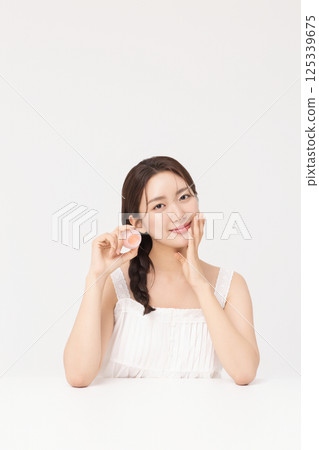 Cropped view of young woman posing with lip balm Cropped view of young woman posing with lip balm 125339675