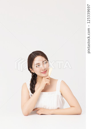 Cropped view of young woman posing with lip balm Cropped view of young woman posing with lip balm 125339697