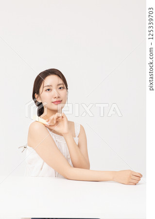 Cropped view of young woman posing with lip balm 125339703