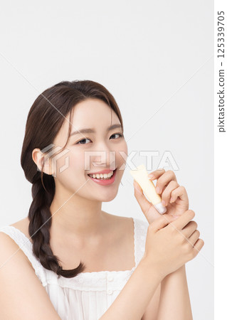 Cropped view of young woman posing with lip balm 125339705