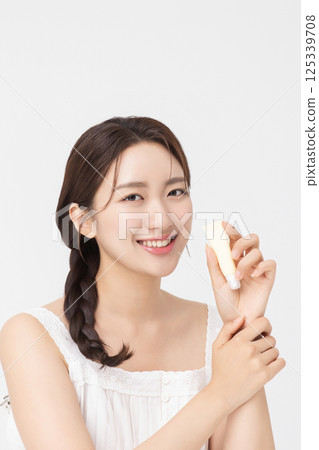 Cropped view of young woman posing with lip balm 125339708