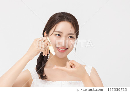 Cropped view of young woman posing with lip balm 125339713