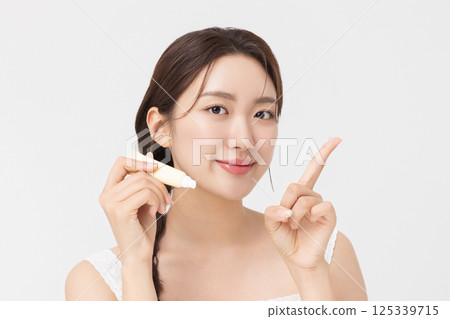 Cropped view of young woman posing with lip balm 125339715