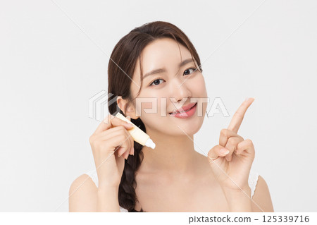 Cropped view of young woman posing with lip balm 125339716