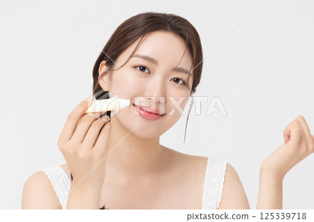 Cropped view of young woman posing with lip balm 125339718