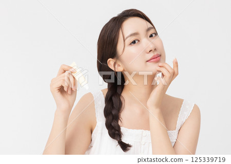 Cropped view of young woman posing with lip balm 125339719