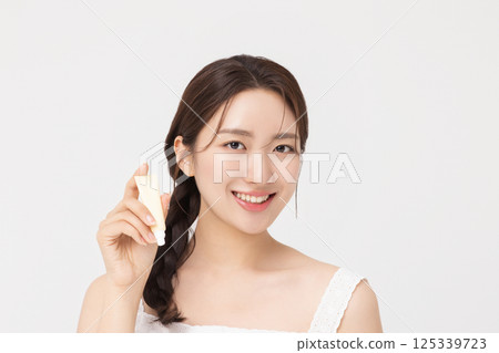 Cropped view of young woman posing with lip balm 125339723