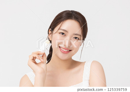 Cropped view of young woman posing with lip balm 125339759