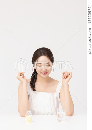 A young woman taking nutritional supplements for her health A young woman taking nutritional supplements for her health 125339764
