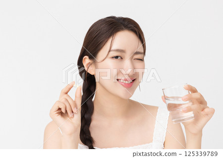 A young woman taking nutritional supplements for her health A young woman taking nutritional supplements for her health 125339789