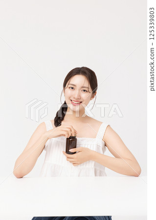 A young woman taking nutritional supplements for her health 125339803