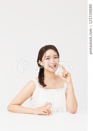 A young woman taking nutritional supplements for her health 125339880