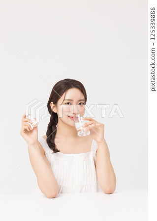 A young woman taking nutritional supplements for her health 125339888