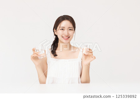 A young woman taking nutritional supplements for her health 125339892