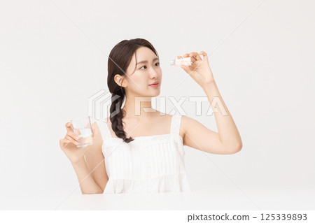 A young woman taking nutritional supplements for her health A young woman taking nutritional supplements for her health 125339893