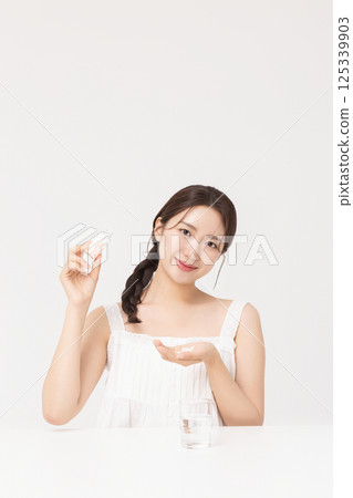 A young woman taking nutritional supplements for her health A young woman taking nutritional supplements for her health 125339903