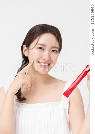 Portrait of young woman posing with health supplement products Portrait of young woman posing with health supplement products 125339949