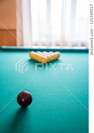 Initial billiard ball arrangement with white balls in a triangle and red cue ball ready for the break. Concept of indoor recreation and personal hobby space 125340017
