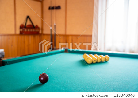 Initial billiard ball arrangement with white balls in a triangle and red cue ball ready for the break. Concept of indoor recreation and personal hobby space 125340046