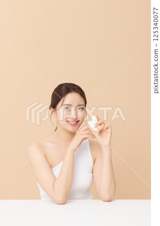 Wearing a shower gown and applying oil to legs Wearing a shower gown and applying oil to legs 125340077