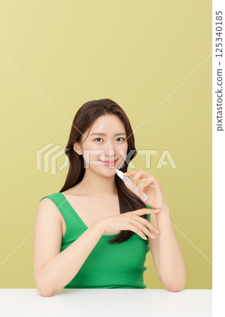 Portrait of young woman taking care of her nails 125340185