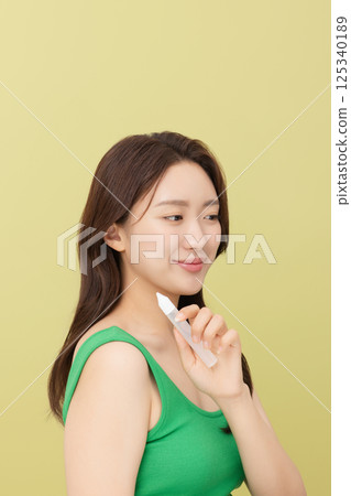 Portrait of young woman taking care of her nails 125340189
