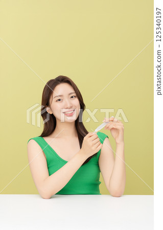 Portrait of young woman taking care of her nails 125340197
