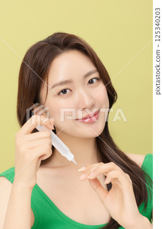 Portrait of young woman taking care of her nails 125340203