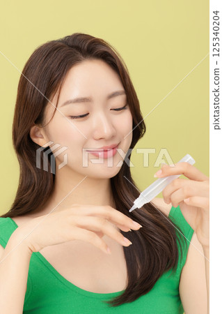 Portrait of young woman taking care of her nails 125340204