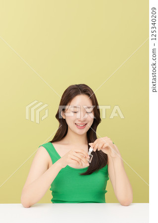 Portrait of young woman taking care of her nails 125340209