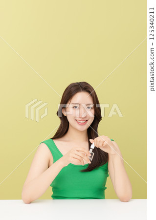 Portrait of young woman taking care of her nails 125340211