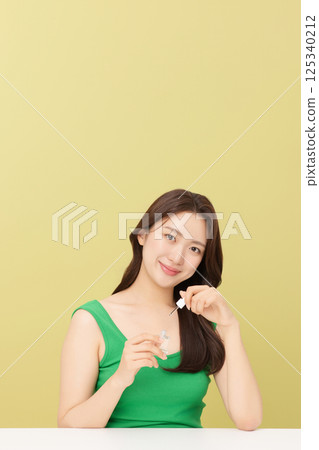 Portrait of young woman taking care of her nails 125340212