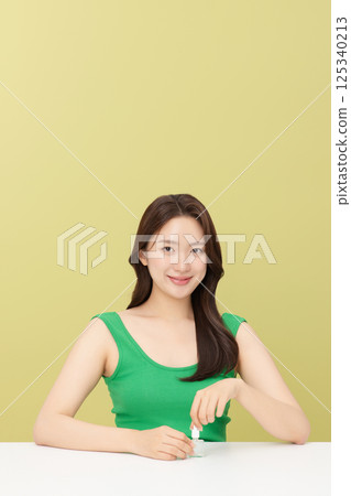 Portrait of young woman taking care of her nails 125340213