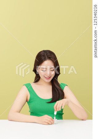 Portrait of young woman taking care of her nails 125340216