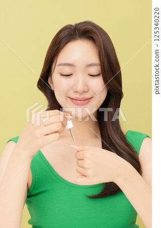 Portrait of young woman taking care of her nails 125340220
