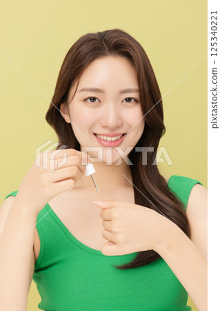 Portrait of young woman taking care of her nails 125340221